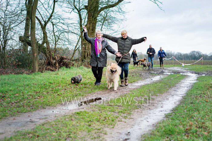 juichende mensen met hond in bos